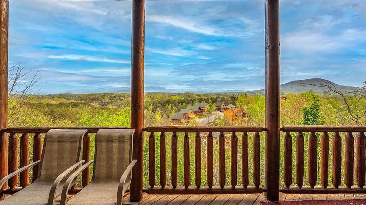 This exterior shot features classic wooden rocking chairs facing a panoramic mountain view from the deck. The tranquil setting is ideal for catching sunrises or stargazing, inviting couples to savor serene moments together.
