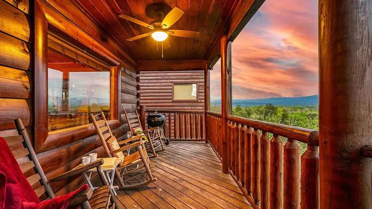 A serene porch scene with wooden rocking chairs, an outdoor grill, and a sweeping view of the mountains and sky. The setting is perfect for unwinding and sharing stories after outdoor adventures, with the sunset visible in the distance.