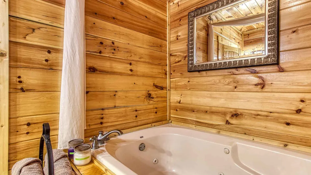 A tranquil bathroom featuring a jacuzzi tub, wooden walls, and a mirror—perfect for unwinding after a long day.